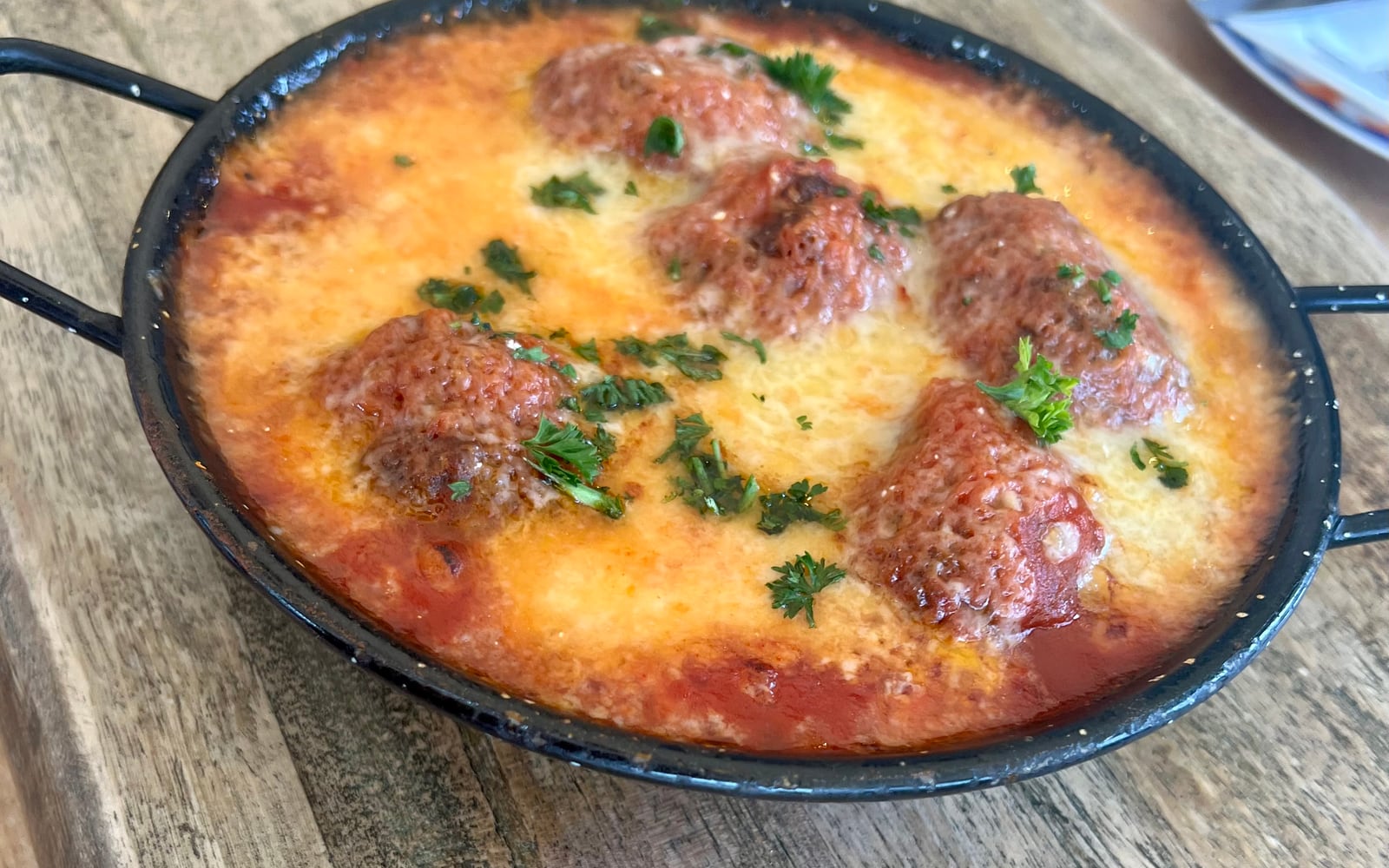 Spanish albóndigas meatballs baked in tomato sauce under melted cheese at The Bank at Bude