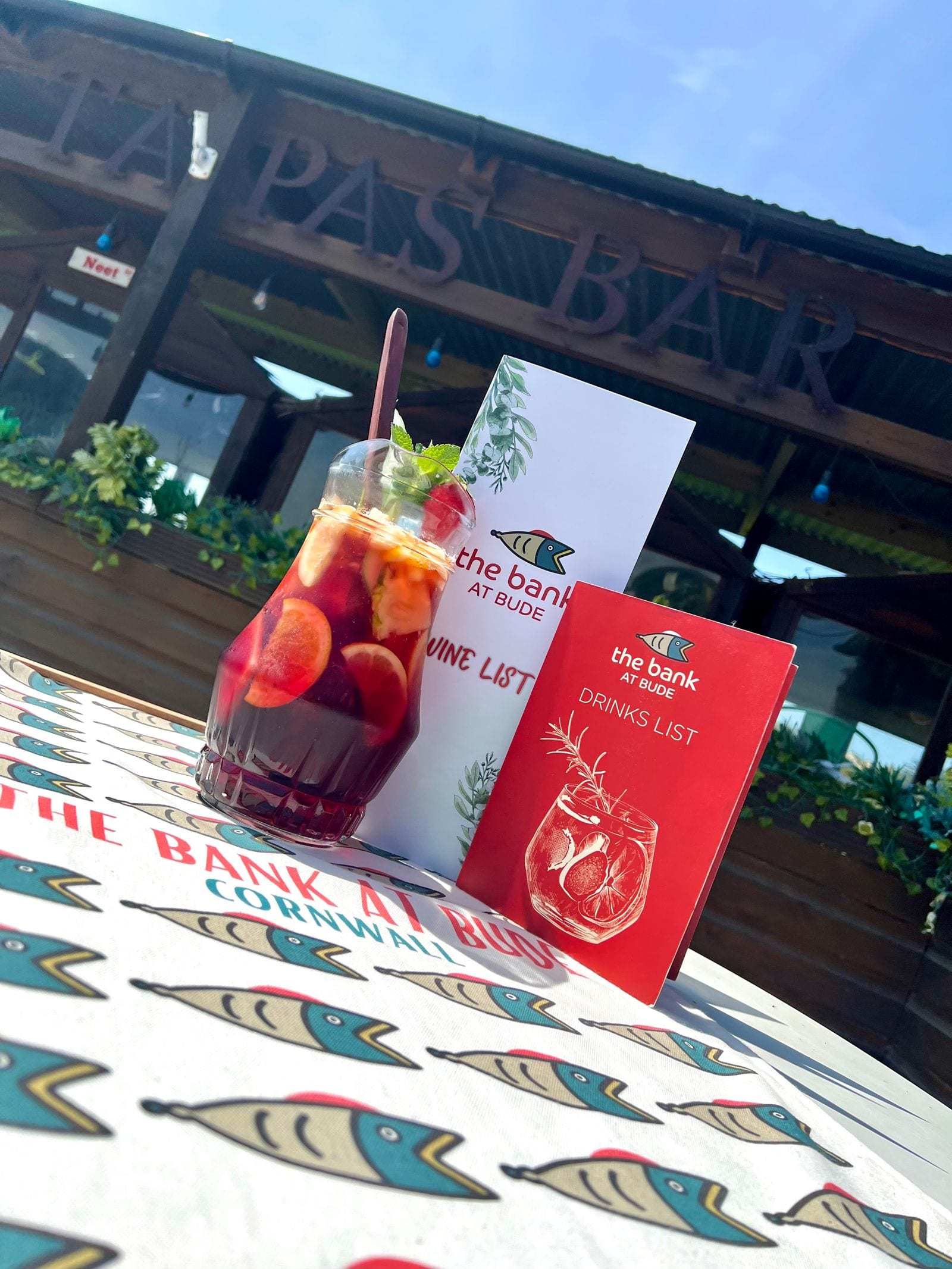A glass of fruit-filled traditional Spanish sangria on the branded fish tablecloth at The Bank at Bude